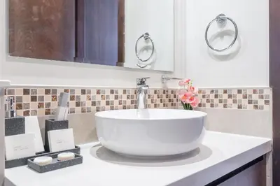 a bathroom with a white sink and a mirror at Burj View - Chic 2BR - 5min Dubai mall Canal in Dubai