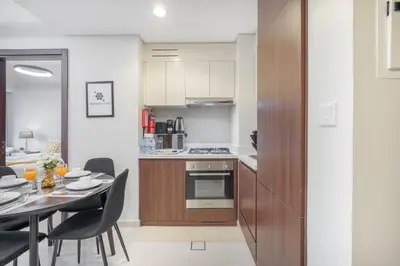 a kitchen and dining room with a table and chairs at Burj View - Chic 2BR - 5min Dubai mall Canal in Dubai