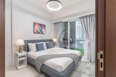 a bedroom with a large bed and a large window at Burj View - Chic 2BR - 5min Dubai mall Canal in Dubai