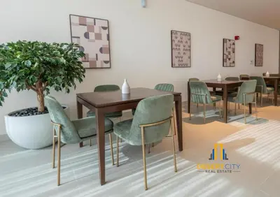 a dining room with a table and green chairs at Cozy & Modern 1 Bedroom Apartment in Downtown Dubai, Hosted by Desert City Stays in Dubai