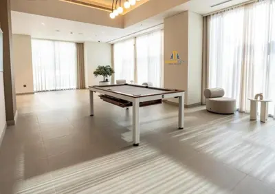 a ping pong table in a large room with windows at Cozy & Modern 1 Bedroom Apartment in Downtown Dubai, Hosted by Desert City Stays in Dubai