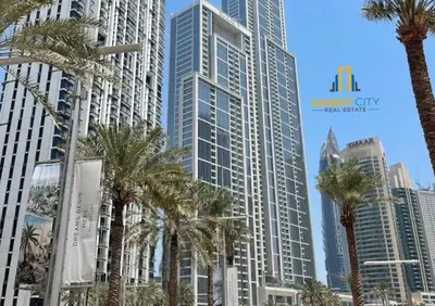 a group of palm trees in front of tall buildings at Cozy & Modern 1 Bedroom Apartment in Downtown Dubai, Hosted by Desert City Stays in Dubai