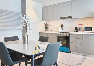 a kitchen with a dining room table and chairs at Cozy & Modern 1 Bedroom Apartment in Downtown Dubai, Hosted by Desert City Stays in Dubai
