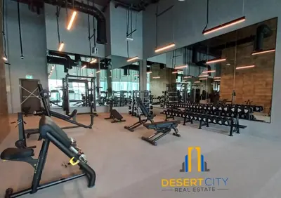 a gym with several treadmills and benches in it at Cozy & Modern 1 Bedroom Apartment in Downtown Dubai, Hosted by Desert City Stays in Dubai