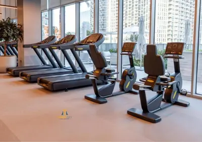 a row of cardio treadmills in a gym at Cozy & Modern 1 Bedroom Apartment in Downtown Dubai, Hosted by Desert City Stays in Dubai