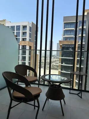a balcony with two chairs and a glass table at Azizi riviera luxury studio apartment monthly rent in Dubai