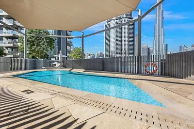a swimming pool on the roof of a building at FIRST CLASS 4BR Burj Khalifa & Fountain View in Dubai