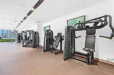 a gym with rows of treadmills and machines at FIRST CLASS 4BR Burj Khalifa & Fountain View in Dubai