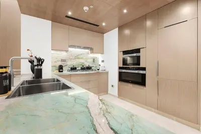 a kitchen with a sink with a marble counter top at FIRST CLASS 4BR Burj Khalifa & Fountain View in Dubai