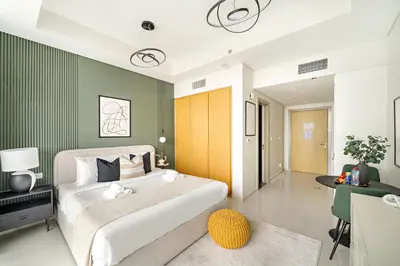 a bedroom with a large white bed and a green wall at Silkhaus Cozy Studio at Business Bay in Aykon City in Dubai