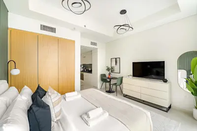 a bedroom with a white bed and a television at Silkhaus Cozy Studio at Business Bay in Aykon City in Dubai