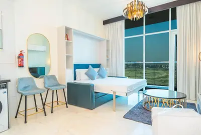 a bedroom with a bed and a table and chairs at Stylish Studio Bayz Danube Burj Khalifa View Pool in Dubai