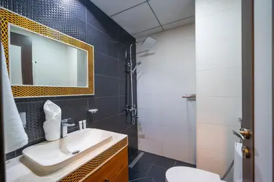 a bathroom with a sink and a mirror and a toilet at Stylish Studio Bayz Danube Burj Khalifa View Pool in Dubai