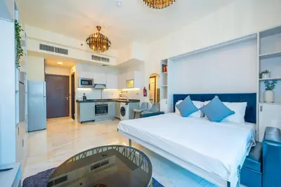 a bedroom with a large bed and a kitchen at Stylish Studio Bayz Danube Burj Khalifa View Pool in Dubai
