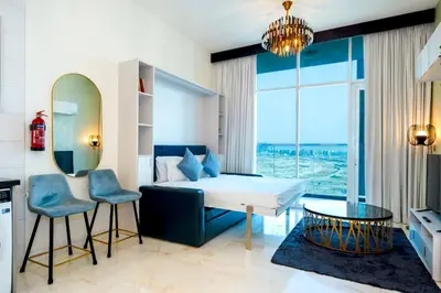 a bedroom with a bed and a table and chairs at Stylish Studio Bayz Danube Burj Khalifa View Pool in Dubai
