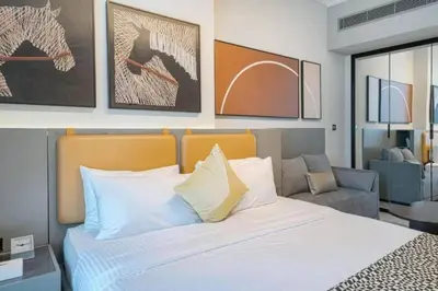 a bedroom with a large bed and a chair at CAICAI Homes Mag 318 Dubai Walking Distance to Dubai Mall in Dubai