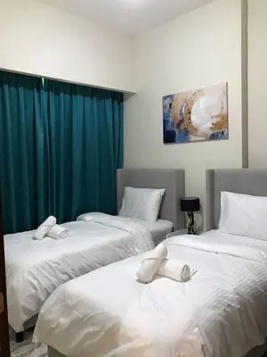 three beds in a room with blue curtains at 2 bhk 3 mins in down town in Dubai