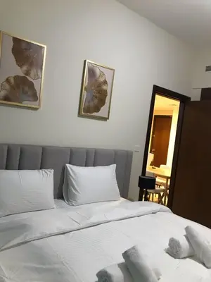 a bedroom with a bed with white sheets and a mirror at 2 bhk 3 mins in down town in Dubai