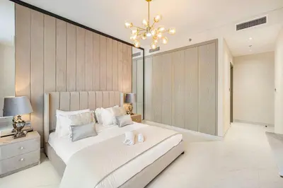 a bedroom with a large bed and a chandelier at Luxury 2 Bedroom plus kids room Burj Khalifa View in Dubai