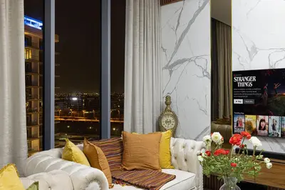 a living room with a white couch and a window at Luxury 2 Bedroom plus kids room Burj Khalifa View in Dubai