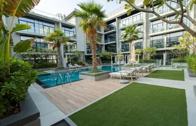 an apartment building with a pool and palm trees at Stylish Retreat - Embrace the Comfort in Dubai