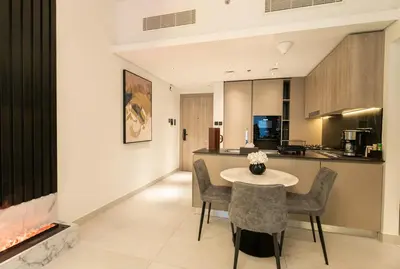 a kitchen and living room with a table and chairs at Stylish Retreat - Embrace the Comfort in Dubai