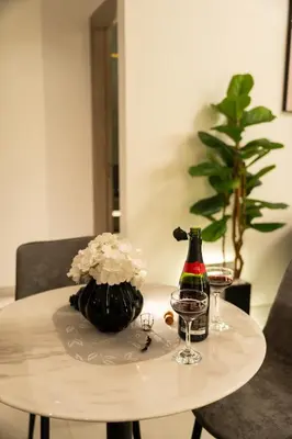 a table with a bottle of wine and two glasses at Stylish Retreat - Embrace the Comfort in Dubai