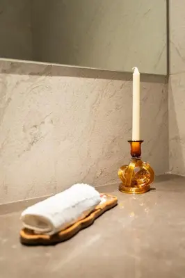 a towel sitting on a counter next to a candle at Stylish Retreat - Embrace the Comfort in Dubai