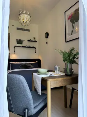a bedroom with a bed and a table and a chair at Roomook Apartments in Dubai