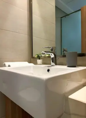 a bathroom with a white sink and a mirror at Roomook Apartments in Dubai
