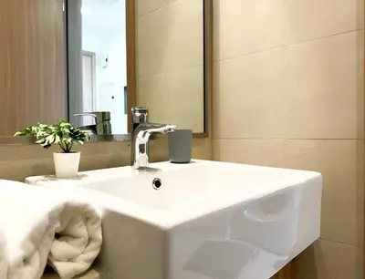 a bathroom with a white sink and a mirror at Roomook Apartments in Dubai