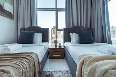 two beds in a room with a window at Chic Waterfront Living - Marina View in Dubai