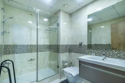 a bathroom with a shower and a toilet and a sink at Chic Waterfront Living - Marina View in Dubai