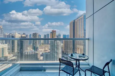 a balcony with a table and chairs and a view of the city at Chic Waterfront Living - Marina View in Dubai