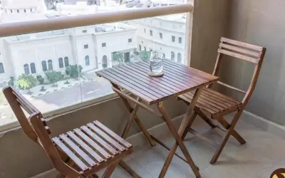 a wooden table and chair next to a window at Dubai Marina-short stay in Dubai