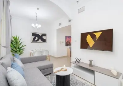 a living room with a couch and a tv on a wall at Dubai Marina-short stay in Dubai