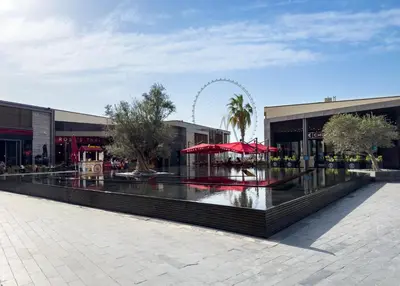 a shopping center with a ferris wheel in the background at Dubai Eye and Sunset Views 1 Bedroom Apartment with Direct Beach Access, Gym, and Pool in Dubai