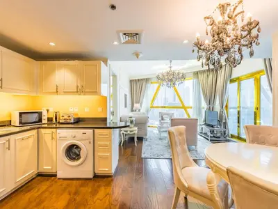 a kitchen and living room with a table and a dining room at Luxury Spacious Condo in the Iconic Park Towers in Dubai