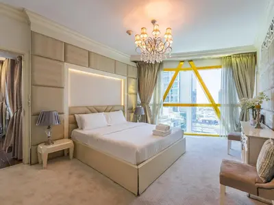 a bedroom with a large bed and a chandelier at Luxury Spacious Condo in the Iconic Park Towers in Dubai