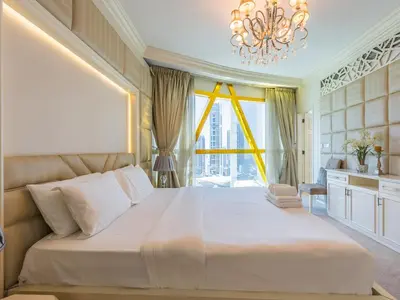 a bedroom with a large bed and a chandelier at Luxury Spacious Condo in the Iconic Park Towers in Dubai