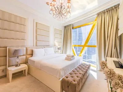 a bedroom with a large bed and a chandelier at Luxury Spacious Condo in the Iconic Park Towers in Dubai