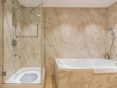 a bathroom with a shower and a tub and a sink at Luxury Spacious Condo in the Iconic Park Towers in Dubai