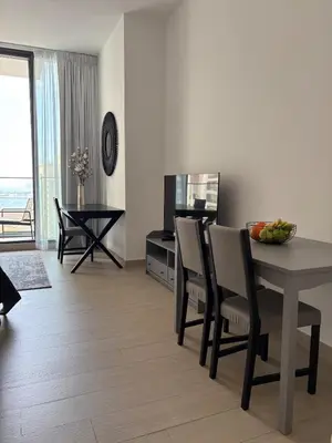 a living room with a table and chairs and a dining room at Luxury Sea View Studio in Dubai Marina in Dubai