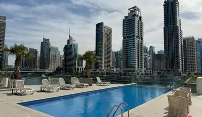 a swimming pool with chairs and a city skyline at Luxury Sea View Studio in Dubai Marina in Dubai
