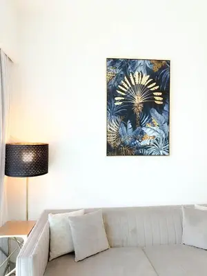 a living room with a couch and a painting on the wall at INA HOMES - Burj Royal 1 BR Stylish Apartment in Dubai