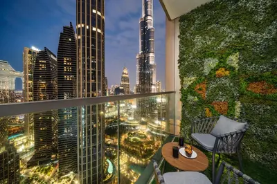 a balcony with a view of the city at night at Luxe Living at Grande Signature - Burj Khalifa and Sea Views - Brand New in Dubai
