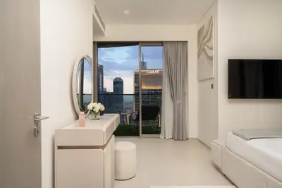 a white bathroom with a sink and a mirror at Luxe Living at Grande Signature - Burj Khalifa and Sea Views - Brand New in Dubai