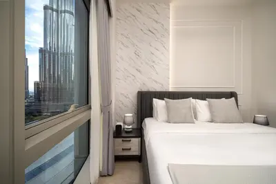 a bedroom with a bed and a large window at Luxe Living at Grande Signature - Burj Khalifa and Sea Views - Brand New in Dubai