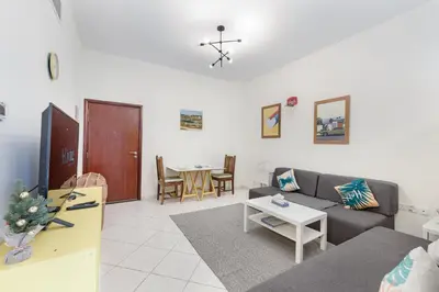 a living room with a couch and a table at ALiving Cozy Studio with Balcony I Marina Pearl- 407 in Dubai