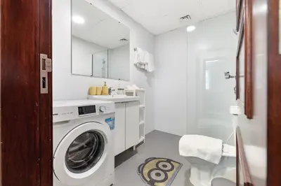 a white bathroom with a washing machine in it at ALiving Cozy Studio with Balcony I Marina Pearl- 407 in Dubai